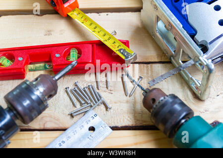 Elektrische Bohrmaschine, Mutter, Maßband, elektrische Säge, Lineal, Schraubendreher, Werkzeuge für die Holzbearbeitung Konzept Baumaschinen Stockfoto