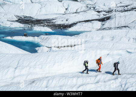 Drei Eisklettern und Gletscher Trekking Guides wandern über den weißen Eis Der Matanuska Gletscher. Stockfoto