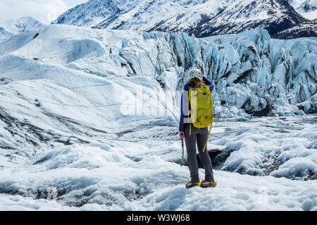 Junge Frau in gletschertouren Gang zu einem Eisfall des unteren Matanuska Gletscher in Alaska. Stockfoto