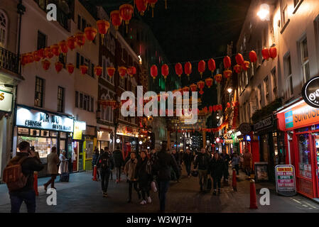 LONDON, ENGLAND, 10. Dezember 2018: die Menschen zu Fuß in China Town, durch Chinesische Laternen während Weihnachten und Neujahr in London, Großbritannien eingerichtet. Stockfoto