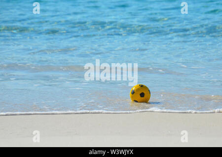 Soccer Ball im Wasser am Strand. Konzept Sport und gesunden aktiven Lebensstil im Freien spielen Fußball am Strand. Stockfoto