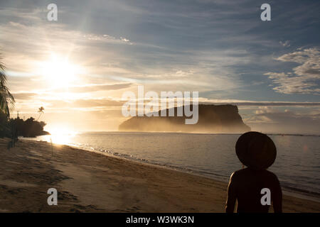 Silhouette der Mann mit Hut, das golden Sunrise anstarren, am sandigen Strand Stockfoto