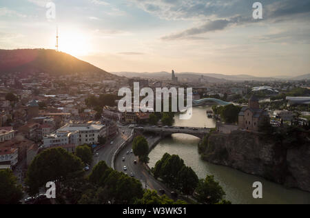 Antenne Stadtbild von Tiflis, Georgien, Sonnenuntergang und das Stadtbild von Tiflis, Georgien, Blick auf die Berge im Hintergrund. Stockfoto