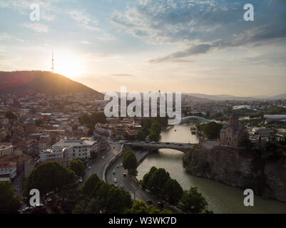 Antenne Stadtbild von Tiflis, Georgien, Sonnenuntergang und das Stadtbild von Tiflis, Georgien, Blick auf die Berge im Hintergrund. Stockfoto