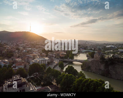 Antenne Stadtbild von Tiflis, Georgien, Sonnenuntergang und das Stadtbild von Tiflis, Georgien, Blick auf die Berge im Hintergrund. Stockfoto