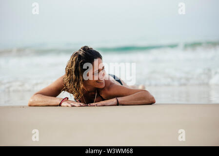 Frau mit Bikini lächelnd und Sonnenbaden am Strand. Stockfoto