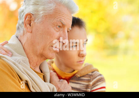 Portrait von traurigen Großvater und Enkel umarmen Stockfoto