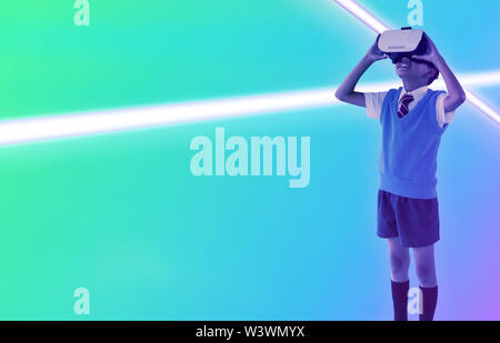Das zusammengesetzte Bild der vollen Länge der Schule junge tragen virtual reality Headset Stockfoto