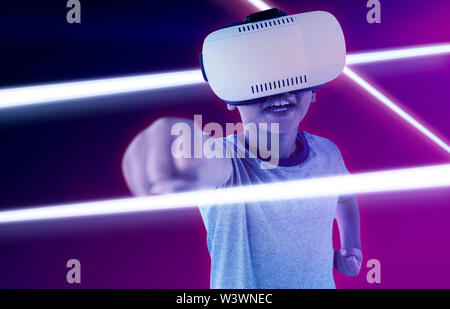 Das zusammengesetzte Bild von lächelnden Jungen tragen virtuelle Headset spielen Stockfoto