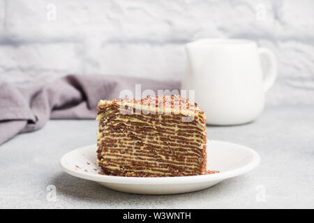 Schokolade Kuchen von dünnen Pfannkuchen und pistaziencreme auf grauem Hintergrund Stockfoto