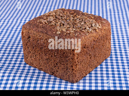 Nahaufnahme einer köstlichen multi-Korn Brot mit Sonnenblumenkernen auf einer blauen Tabelle Stockfoto