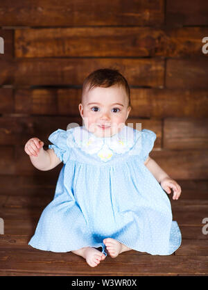 Süße kleine Mädchen auf einem Holz- Hintergrund. Stockfoto