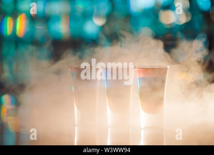 Bunte leckere Schüsse an der Bar aus Holz. Stockfoto