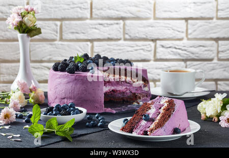 Festliche Käsekuchen, Heidelbeere und Blackberry Schokolade Biskuit, überlagert mit Frischkäse auf Platten auf einer konkreten Tabelle mit Mauer und Frische f Stockfoto