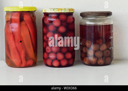 Vielzahl von haltbar gemachten Lebensmitteln in Gläsern - Konfitüre, Marmelade, Kirschen, rote Paprika, Gemüse und Früchte. Fermentierter Lebensmittel. Herbst canning Stockfoto