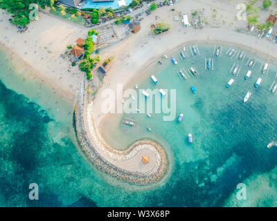 Antenne drone Blick auf Meer, Boote, Strand, Ufer in Sanur, Bali, Indonesien mit traditionellen Balinesischen Fischerbooten unglaublich blaue Meer. Stockfoto