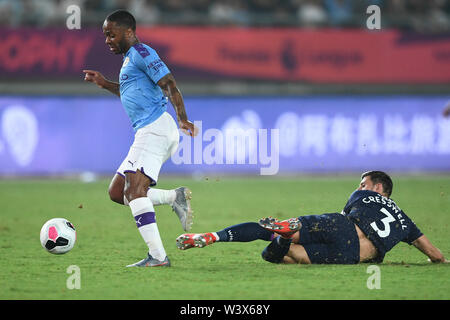 Raheem Sterling, links, von Manchester City F.C. der englischen Liga Champions passt den Ball gegen Aaron Cresswell von West Ham United F.C. im Halbfinale der Premier League Asien Trophy 2019 in Nanjing, Provinz Jiangsu, China, 17. Juli 2019. Manchester City F.C. besiegte West Ham United F.C. 4-1. Stockfoto