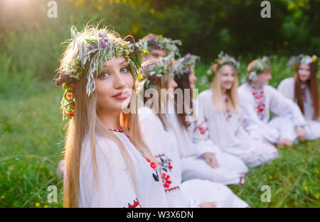 Hochsommer. Sind eine Gruppe von jungen Menschen der Slawischen aussehen Sitzen am Lagerfeuer. Stockfoto