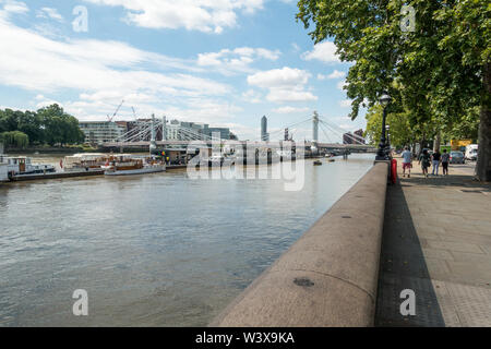 Blick auf die Themse, die Menschen zu Fuß entlang der Promenade, Chelsea Embankment, Thames Embankment, London, England, Großbritannien Stockfoto