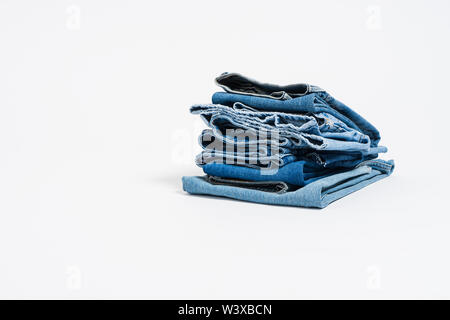 Stapel von verschiedenen Blau Jeans auf weißem Hintergrund. Denim mit kopieren. Stockfoto