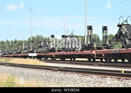 Militärische Fahrzeuge und Ausrüstungsgegenstände von der 1158th Transportation Company und die 107 Oberfläche Wartung Unternehmen der Wisconsin National Guard sind auf triebwagen Juli 12, 2019, am Fort McCoy, Wis. Die Ausstattung war in Fort Hood, Texas, geliefert, ein Teil einer großen Übung später im Jahr werden geladen. Die Schiene wird geladen und die damit verbundenen Arbeiten wurde von der 1158th und 107 Soldaten, Soldaten, 829Th Engineer Unternehmen und Mitarbeiter mit den Fort McCoy Logistics Readiness Center Transport Division. (U.S. Armee Foto von Scott T. Sturkol, Public Affairs Office, Fort McCoy, Wis.) Stockfoto