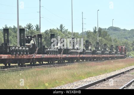 Militärische Fahrzeuge und Ausrüstungsgegenstände von der 1158th Transportation Company und die 107 Oberfläche Wartung Unternehmen der Wisconsin National Guard sind auf triebwagen Juli 12, 2019, am Fort McCoy, Wis. Die Ausstattung war in Fort Hood, Texas, geliefert, ein Teil einer großen Übung später im Jahr werden geladen. Die Schiene wird geladen und die damit verbundenen Arbeiten wurde von der 1158th und 107 Soldaten, Soldaten, 829Th Engineer Unternehmen und Mitarbeiter mit den Fort McCoy Logistics Readiness Center Transport Division. (U.S. Armee Foto von Scott T. Sturkol, Public Affairs Office, Fort McCoy, Wis.) Stockfoto