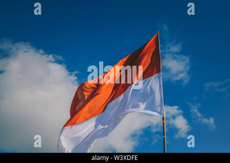 Indonesien Fahne am Mast woonden auf blauen Himmel Hintergrund Stockfoto