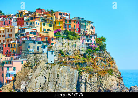 Malerische Häuser an der felsigen Küste in Manarola - eine kleine Stadt in den Cinque Terre, La Spezia, Italien Stockfoto