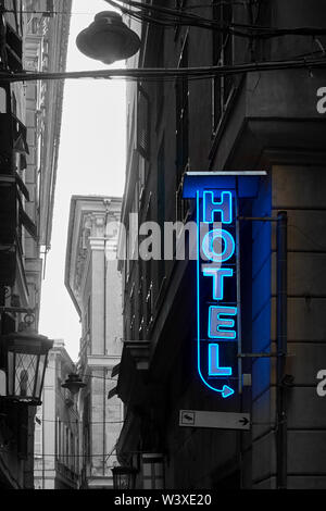 Beleuchtete Neon Hotel Schild in der städtischen Straße. Teilweise Schwarz/Weiß-Bild Stockfoto