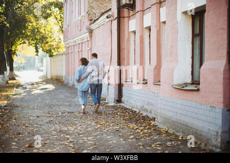 Rückansicht des Jungen umarmen Paar im Park im Herbst Stockfoto