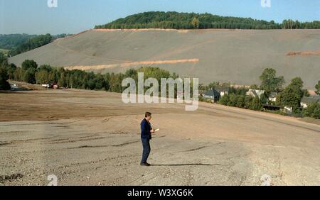 Eingereicht - 01. Januar 1992, Berlin, Aue: Sachsen/DDR/Energie/1992 Uran Dumps in Schlema in der Nähe von Aue, Messung der Radioaktivität. Die Sanierung des großen Umweltschäden hat begonnen. Der Heap abgeflacht ist und Terrassen sind, Büsche gepflanzt wird. Zugang für die Bevölkerung nicht für eine sehr lange Zeit möglich sein. Die Renovierung wird durch die Wismut AG durchgeführt werden. Ein Bagger verteilt eine Mischung von Mutterboden und Asche//Erzgebirge/Umwelt/Atom/URAN/Bergbau den deutsch-sowjetischen Aktiengesellschaft wurde nach der Entstehung der DDR, der Sowjetunion Furth zu ermöglichen gegründet Stockfoto