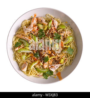 Udon mit Huhn und Erdnuss Knoblauch Sauce mit Sesam in einer weißen Schüssel auf weißem Hintergrund. Stockfoto