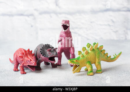 Dinosaurier auf einem grauen Hintergrund. Kunststoff Gummi Spielzeug. Selektiver Fokus Stockfoto