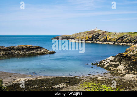 Ruhige blaue Meer in Porth Eilian und Point Lynas/Trwyn Eilian Leuchtturm. Llaneilian, Isle of Anglesey, North Wales, UK, Großbritannien Stockfoto