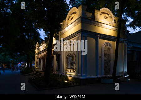 Ukraine, Odessa, deribasivska Street, 11. Juni 2019. Blick auf den alten und schönen Odessa cafe Gebäude in der Stadt garten bei Sonnenuntergang. Stockfoto