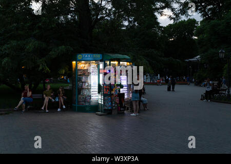 Ukraine, Odessa, deribasivska Street, 11. Juni 2019. Eine kleine beleuchtete Kiosk in der Stadt garten bei Sonnenuntergang. Stockfoto