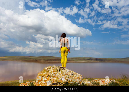 Attraktive Frau steht vor dem See. Entspannen Sie sich und Reisen. Stockfoto