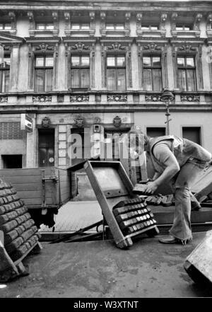 Eingereicht - 01. Januar 1979, Berlin: Berlin/Bezirk Kreuzberg/12/1980 Sanierungsgebiet SO36, Sorauer Straße: Der kohlenmann lädt die Briketts in die Hucke und trägt sie in die Wohnungen. //Gehäuse/Energie/Kohle/Foto: Paul Glaser/dpa-Zentralbild/ZB Stockfoto