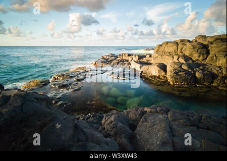 Queen's Bad ist ein tide pool unter den vulkanischen Felsen am Strand in Princeville Kauai, Hawaii, USA, beliebt bei Touristen, aber gefährlich bei rauer See Stockfoto