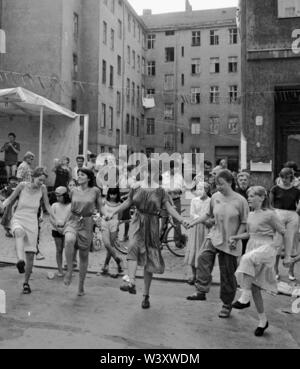 Eingereicht - 01. Januar 1982, Berlin: Berlin-Bezirke/Kreuzberg/Festival 1982 in der Cuvrystrasse, unter anderem von der evangelischen Kirche und die Hausbesetzer in der Straße organisiert. Die erste Hausbesetzung in Berlin fand in dieser Straße im Jahr 1979. Bewohner tanzen vor einem Hinterhof//Dance/Gehäuse/das Leben in der Stadt Foto: Paul Glaser/dpa-Zentralbild/ZB Stockfoto