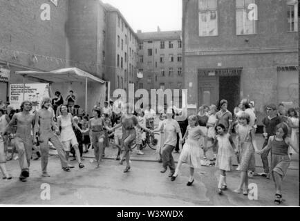 Eingereicht - 01. Januar 1982, Berlin: Berlin-Bezirke/Kreuzberg/Festival 1982 in der Cuvrystrasse, unter anderem von der evangelischen Kirche und die Hausbesetzer in der Straße organisiert. Die erste Hausbesetzung in Berlin fand in dieser Straße im Jahr 1979. Bewohner tanzen vor einem Hinterhof//Dance/Gehäuse/das Leben in der Stadt Foto: Paul Glaser/dpa-Zentralbild/ZB Stockfoto