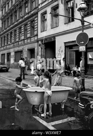 Eingereicht - 01. Januar 1982, Berlin: Berliner Bezirke/Kreuzberg/1982 Cuvrystrasse. Bewohner haben eine Kreuzberg Badehaus: eine alte Badewanne, einen gartenschlauch auf die Laterne gebaut. Ein großer Spaß für die Kinder. //Gehäuse/Sommer/Armut/Foto: Paul Glaser/dpa-Zentralbild/ZB Stockfoto