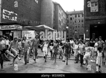 Eingereicht - 01. Januar 1982, Berlin: Berlin-Bezirke/Kreuzberg/Festival 1982 in der Cuvrystrasse, unter anderem von der evangelischen Kirche und die Hausbesetzer in der Straße organisiert. Die erste Hausbesetzung in Berlin fand in dieser Straße im Jahr 1979. Bewohner tanzen vor einem Hinterhof//Dance/Gehäuse/das Leben in der Stadt Foto: Paul Glaser/dpa-Zentralbild/ZB Stockfoto