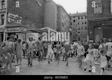 Eingereicht - 01. Januar 1982, Berlin: Berlin-Bezirke/Kreuzberg/Festival 1982 in der Cuvrystrasse, unter anderem von der evangelischen Kirche und die Hausbesetzer in der Straße organisiert. Die erste Hausbesetzung in Berlin fand in dieser Straße im Jahr 1979. Bewohner tanzen vor einem Hinterhof//Dance/Gehäuse/das Leben in der Stadt Foto: Paul Glaser/dpa-Zentralbild/ZB Stockfoto