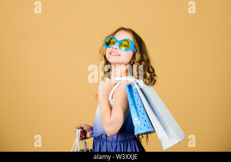 Kind Fashion girl Sonnenbrille halten. Favorite Kinder Marke. Mädchen mit Einkaufstasche. Shopping tour im Ausland. Sommer Saison verkaufen. Shopping und Einkauf. Schwarzer Freitag. Verkauf Rabatt. Shopping Tag. Stockfoto