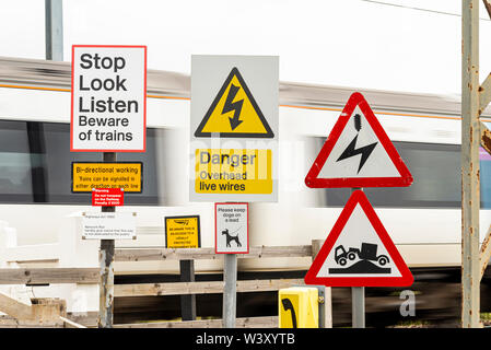 Unbeaufsichtigte Bahnübergang, unkontrollierte Tore in einem Feld. C2C-Linie durch Hadleigh Country Park, Essex, Großbritannien. Recht der Öffentlichkeit. Warnung Stockfoto