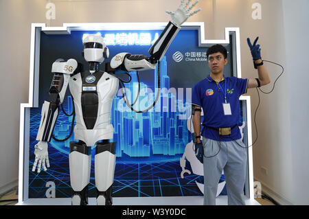 (190718) -- YINGTAN, Juli 18, 2019 (Xinhua) - ein Mitarbeiter steuert einen Roboter mit 5G-Technologie während der jiangxi International Mobile Internet der Dinge Expo 2019 in Yingtan, der ostchinesischen Provinz Jiangxi, 18. Juli 2019. (Xinhua / Zhou Mi) Stockfoto