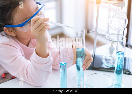 Asiatische kind Chemiker Holding geben. das Reagenzglas in der Hand im Labor lernen Chemie Experiment. Wissenschaftler der Chemie und Wissenschaft Bildung Konzept. Kinder Stockfoto
