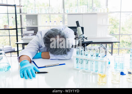 Erschöpft schlafen Wissenschaftler im Labor. Menschen Lebensstile und Beruf Konzept. Wissenschaft und Experiment im Labor Thema. Stockfoto