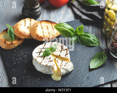 Camembert Grill, auf schwarzen Stein Hintergrund Stockfoto